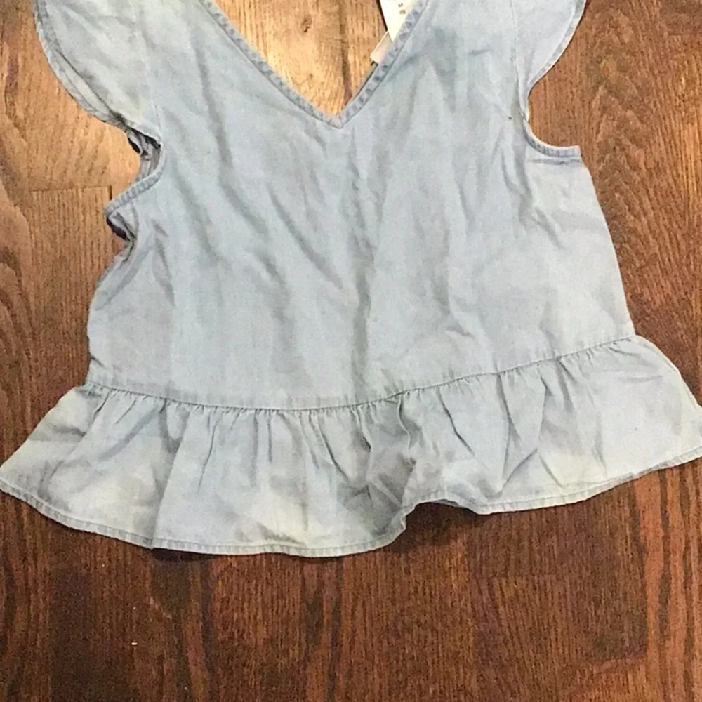 Gap - children's top is made of light-wash blue denim cotton.